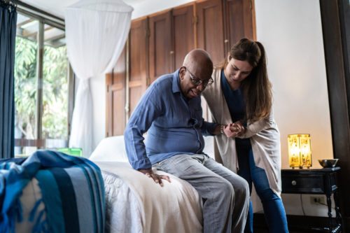 A female health care worker from Harford Belair helps rehab a senior male client.