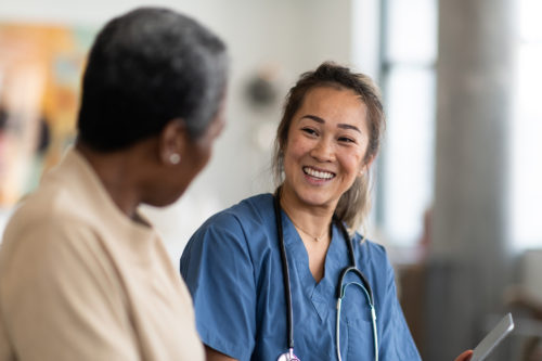 Medical staff from Harford Belair speaks with senior female client.