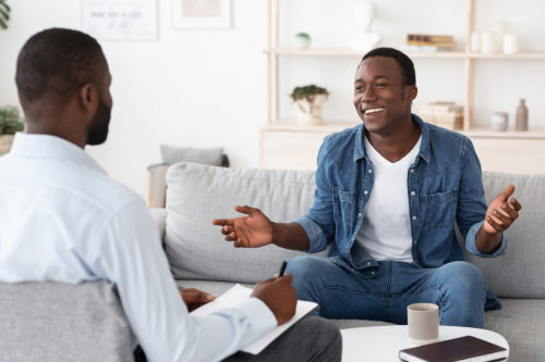 A young teenage male client speaks with male counselor at Harford Belair.