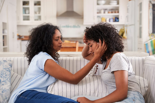 A mother consoles troubled teenage daughter.
