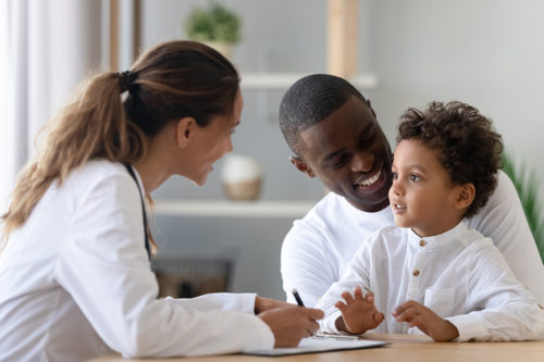 A young toddler with his father, speak to medical staff at Harford Belair.